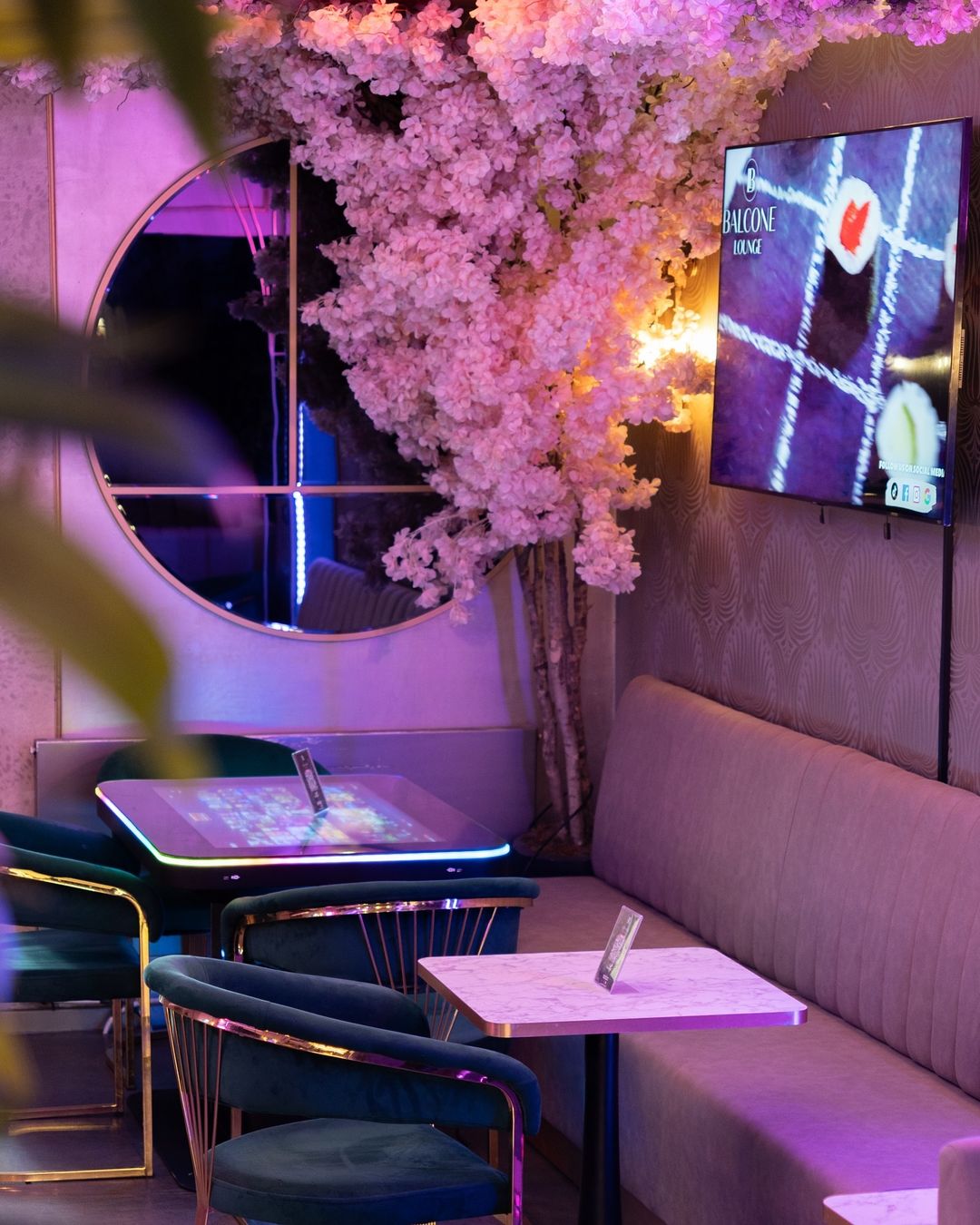 Die Balcone Lounge mit Blüten, gemütlichen Sitzplätzen und stimmungsvoller Beleuchtung